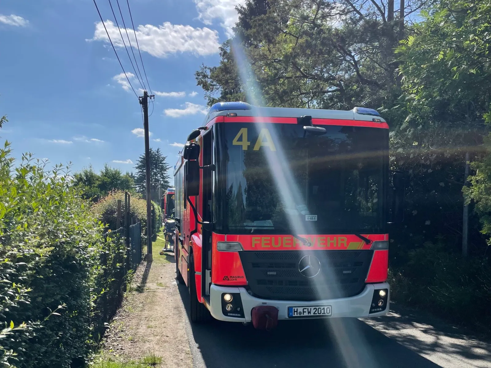 Ein Feuerwehrfahrzeug steht vor einem Garten